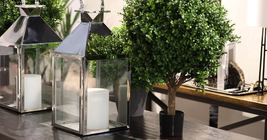 Elegant indoor lanterns and topiary on a wooden table
