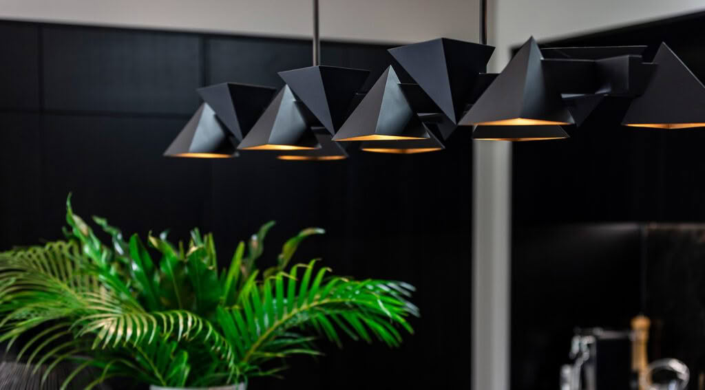 Modern black geometric pendant lights over kitchen counter