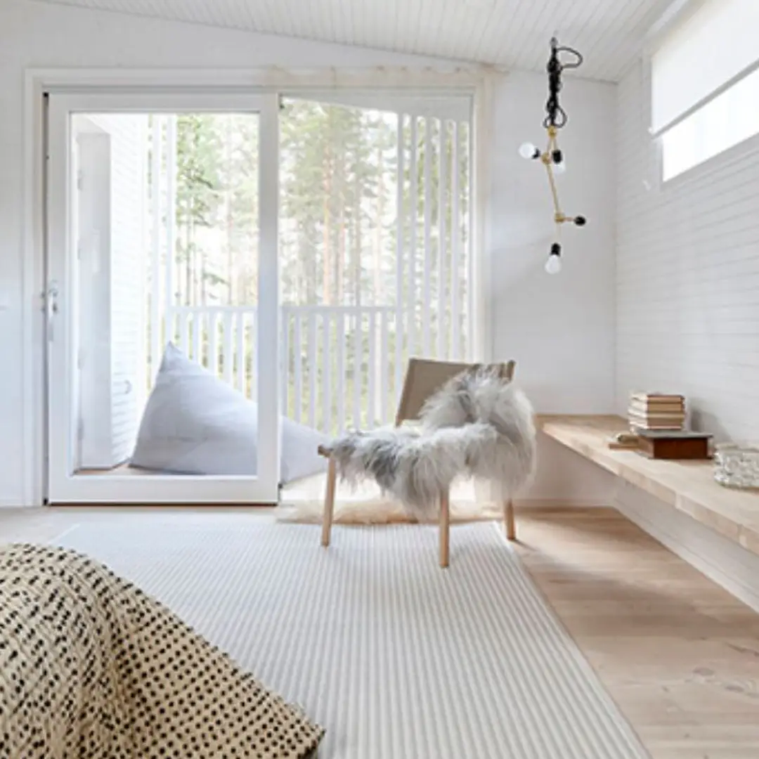 Cozy minimalist bedroom with nature view through glass door