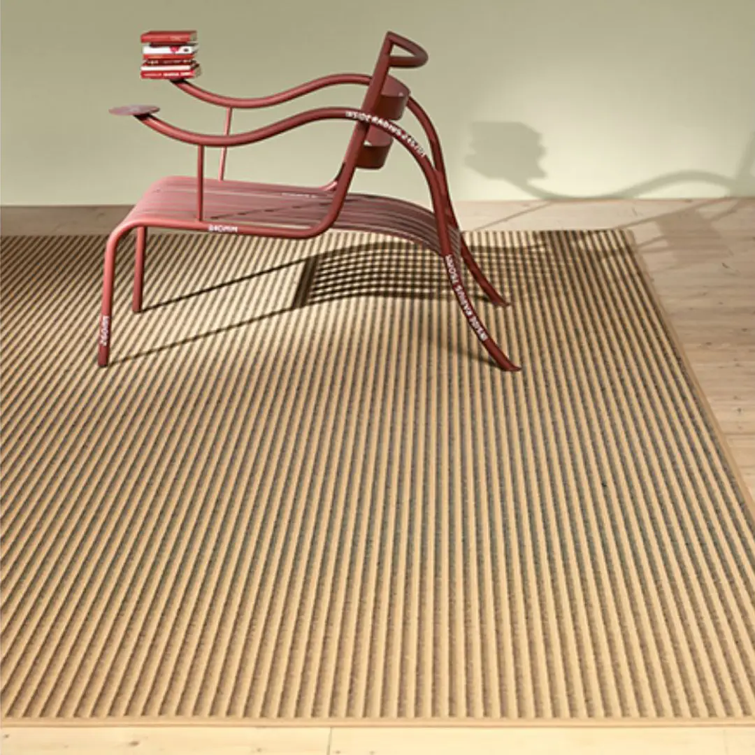 Red metal garden bench with books on warm day