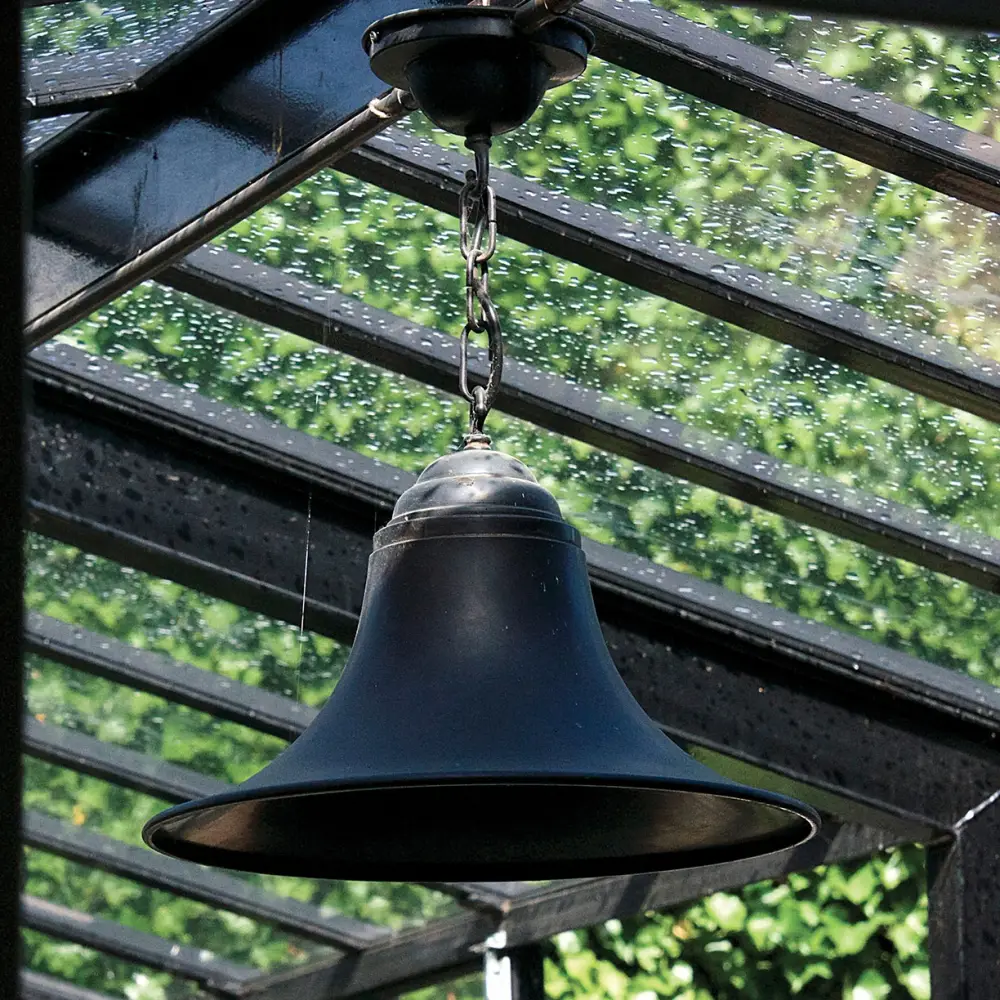 Hanging bell against a rainy window backdrop