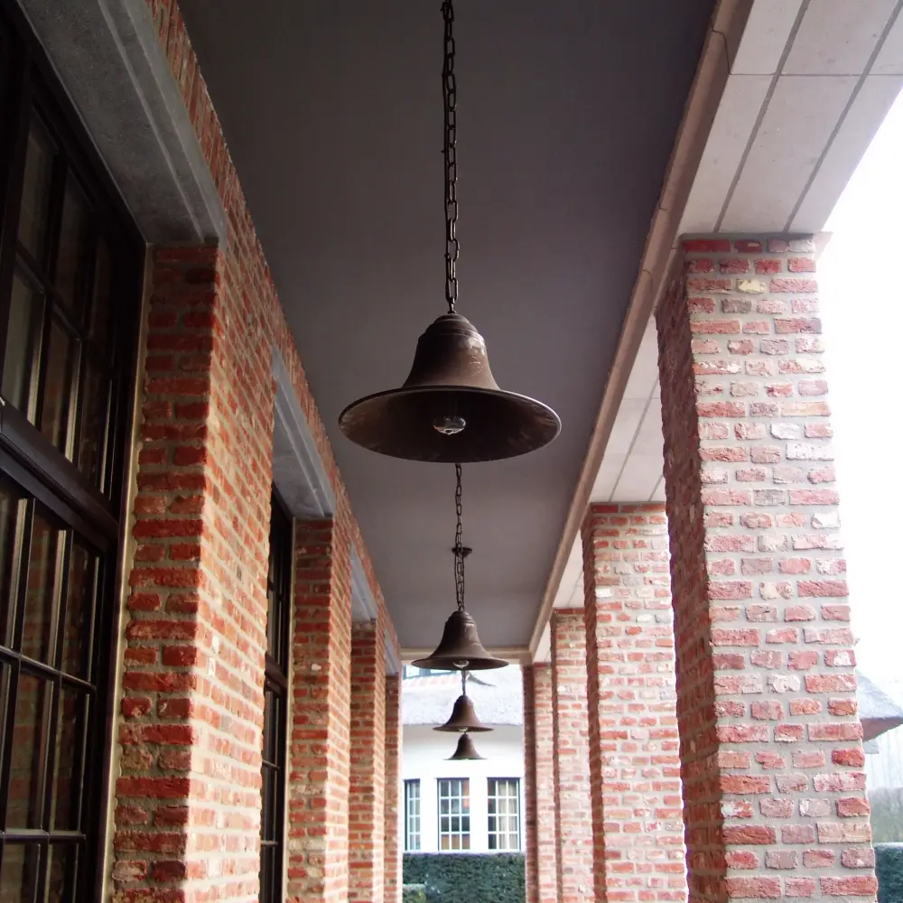 Vintage bell pendants hanging along brick corridor