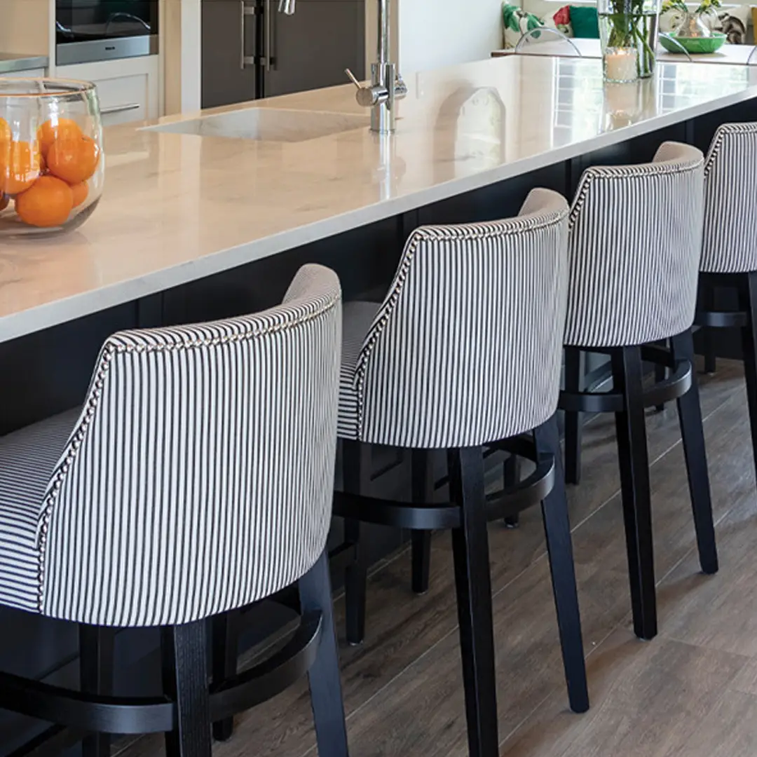 Modern kitchen bar with striped chairs and marble countertop