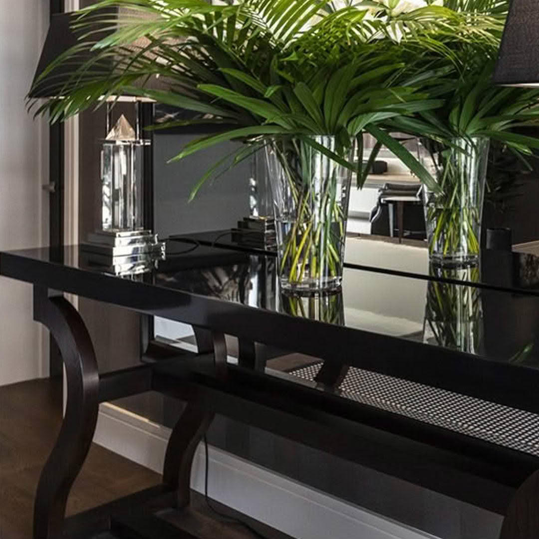 Elegant black console table with decorative plants and lantern
