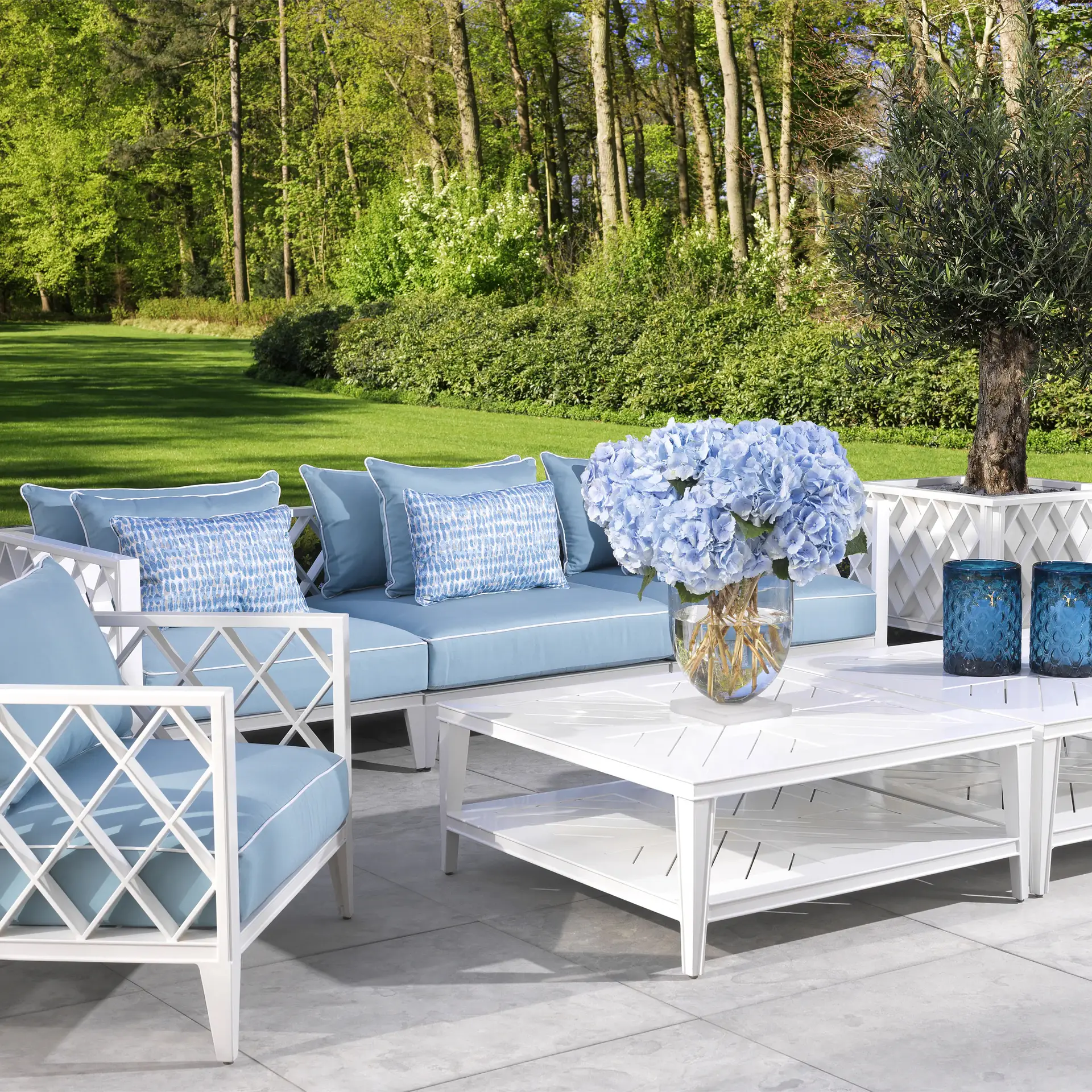 Elegant outdoor furniture set with blue cushions in garden