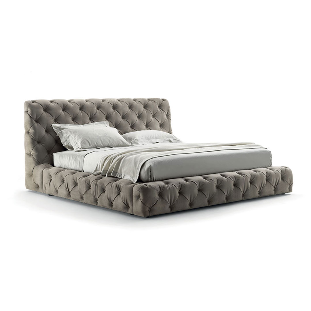 Luxurious gray tufted king-sized bed with pillows