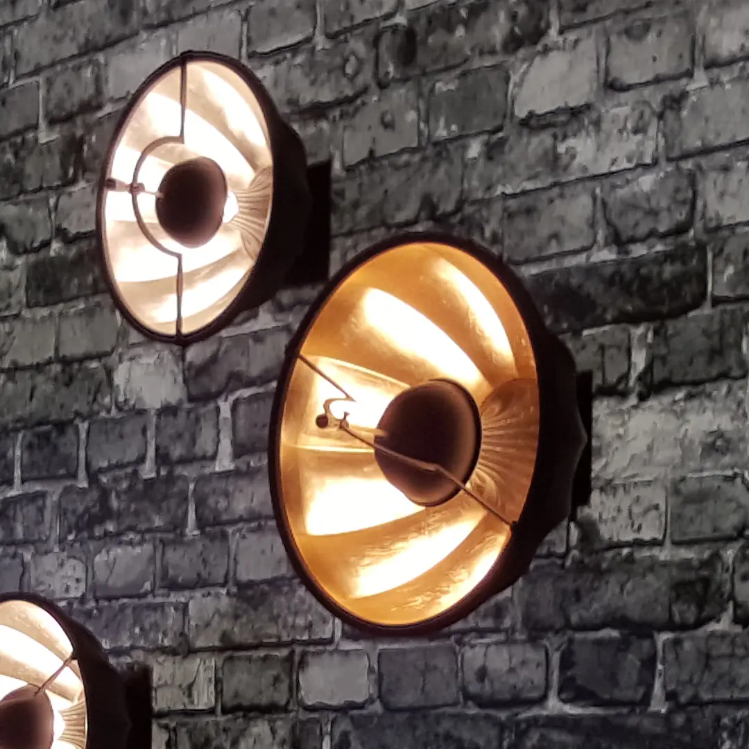 Warm illuminated wall lamps on textured brick wall