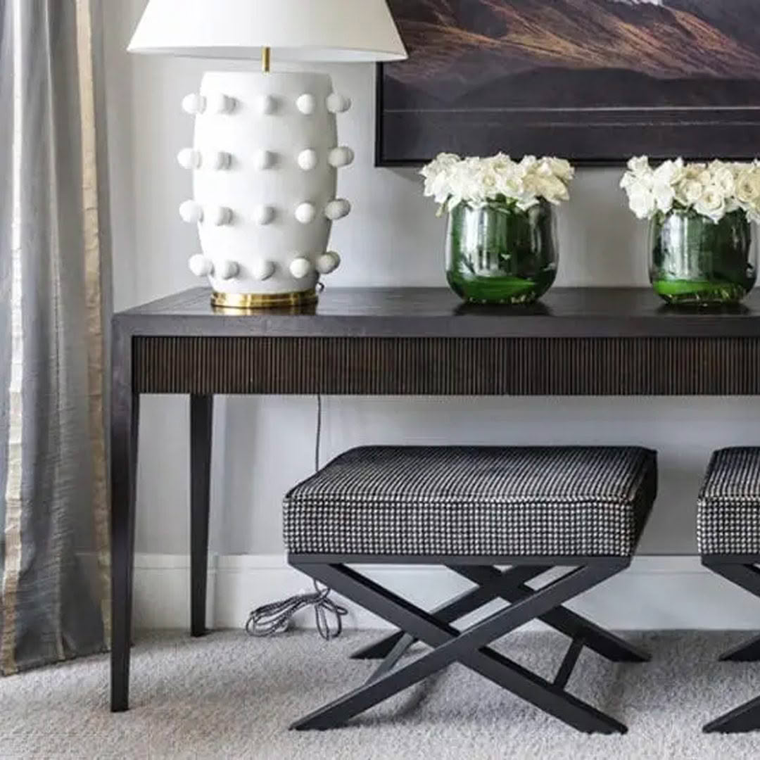 Elegant console table with lamp and flower vases