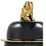 Gold flame sculpture on black bowler hat