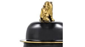 Gold flame sculpture on black bowler hat