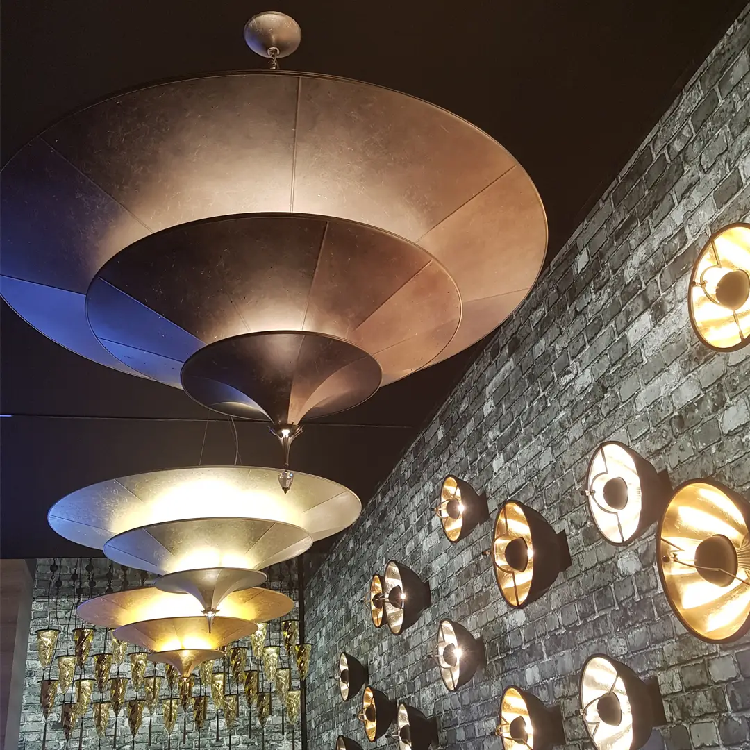 Modern pendant lights above, wall-mounted lamps on stone wall