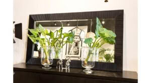 Decorative setup with mirror, plants, and small sculptures