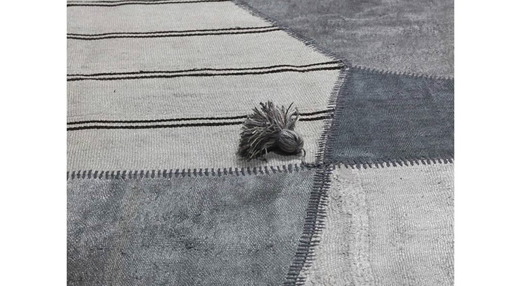 Textured gray throw rug with decorative tassel