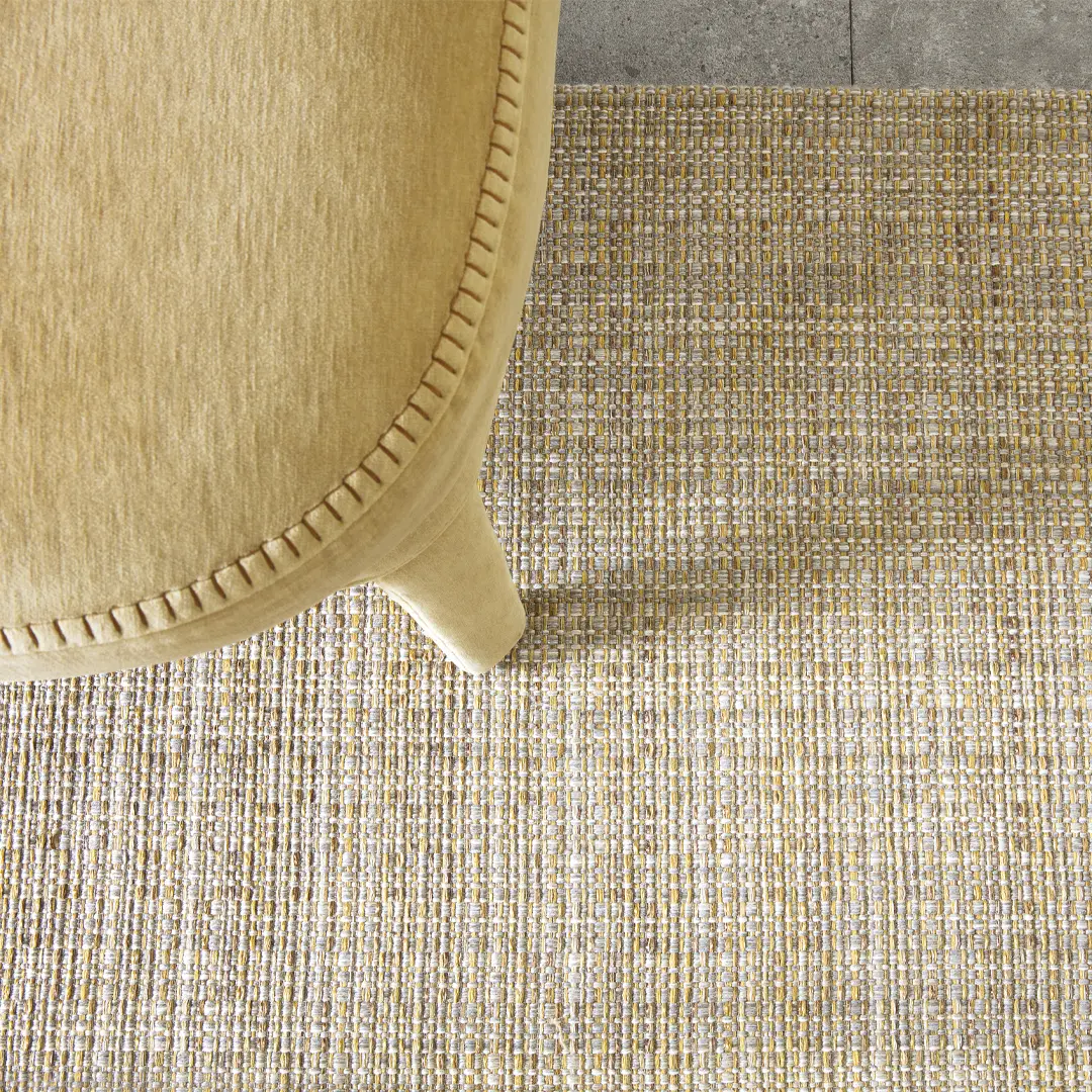 Tan chair leg on textured multicolored woven rug