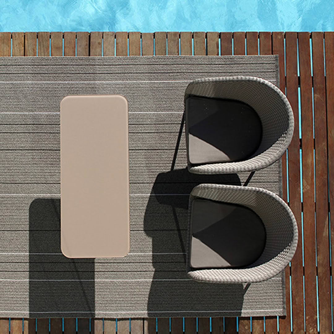 Poolside chaise lounges and table on deck