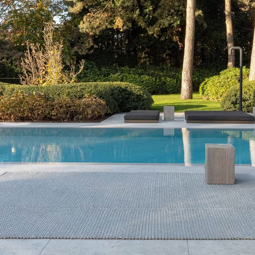 Elegant backyard pool with loungers and lush greenery