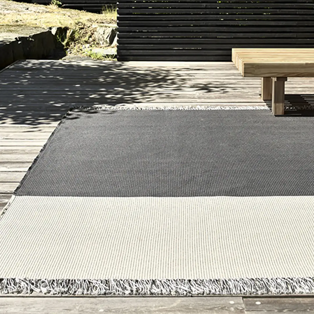 Outdoor textured rug on wooden patio deck