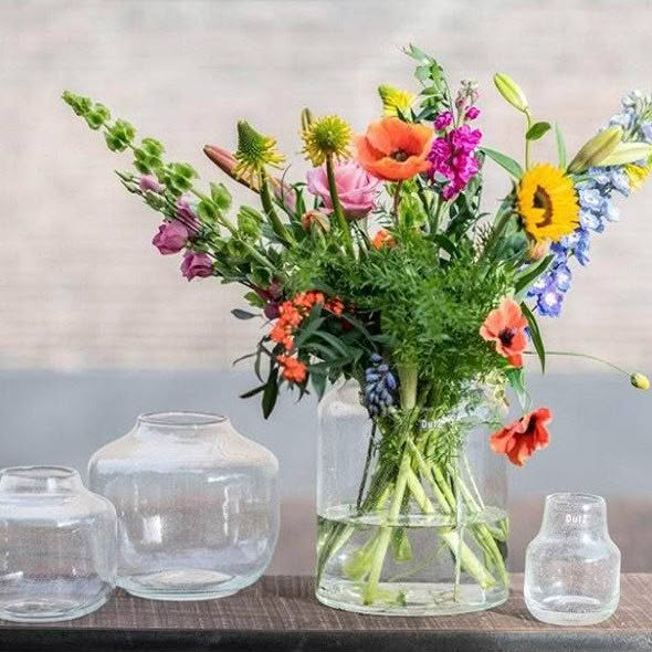 Colorful wildflowers arranged in clear glass vase