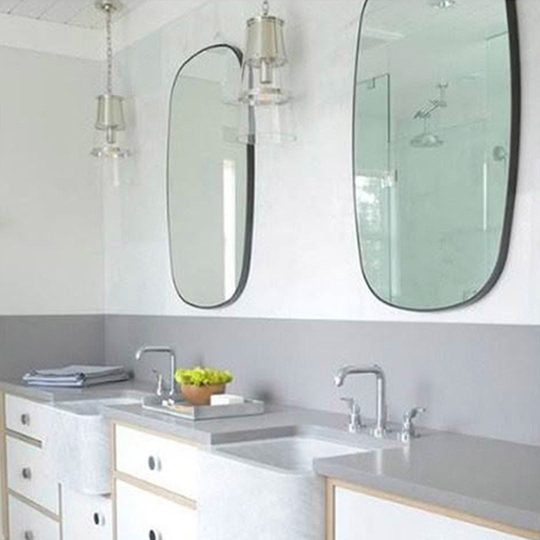 Modern double vanity bathroom with oval mirrors and lights