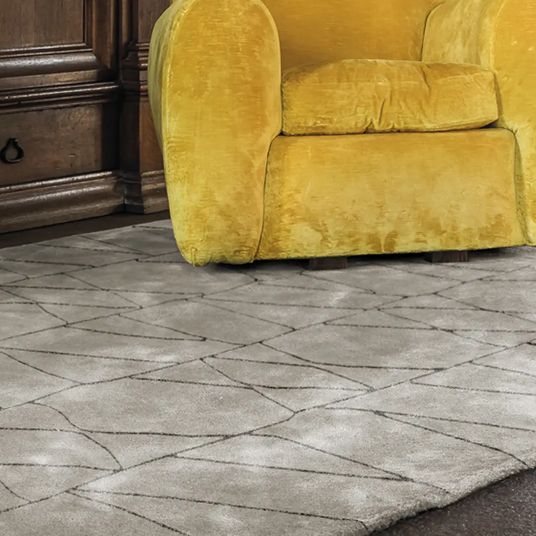 Yellow velvet sofa on geometric patterned gray rug
