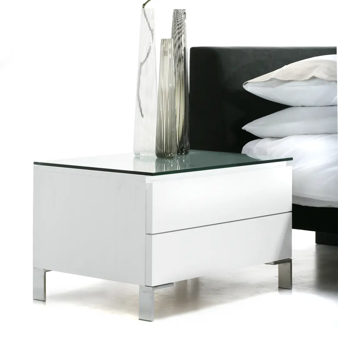 Modern white bedside table with decorative glass vases
