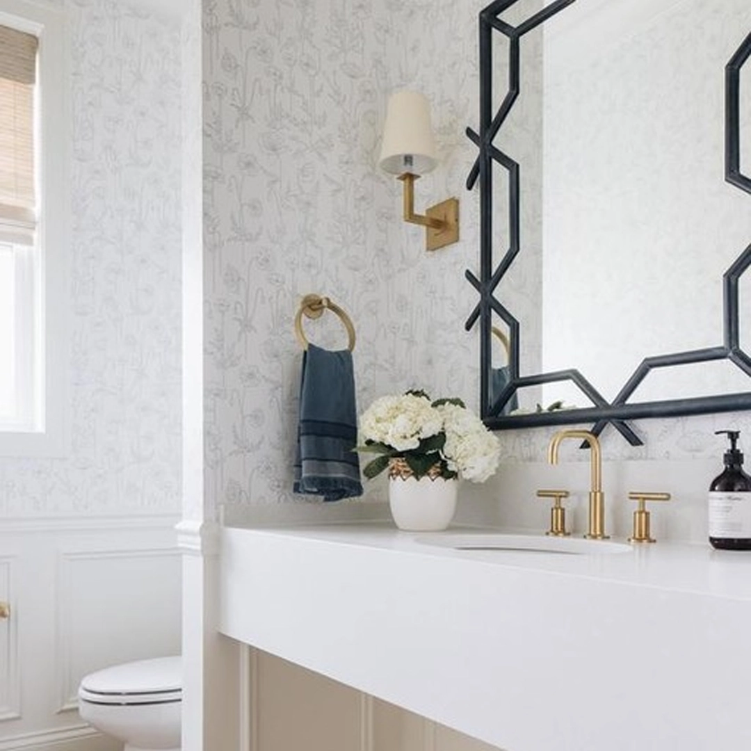 Elegant bathroom with floral wallpaper and gold fixtures