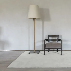 Minimalist floor lamp next to modern chair on rug