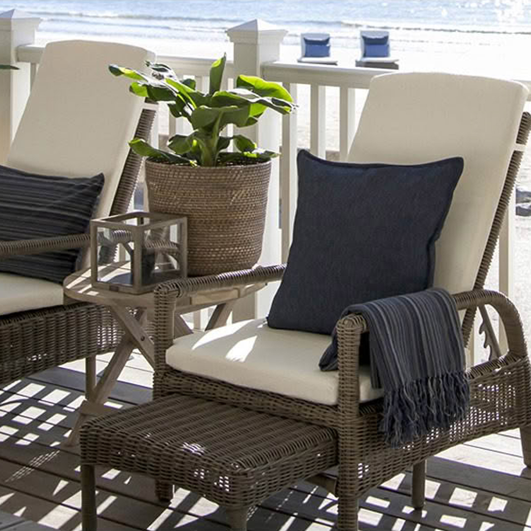 Cozy beachfront patio chairs with cushions and plant