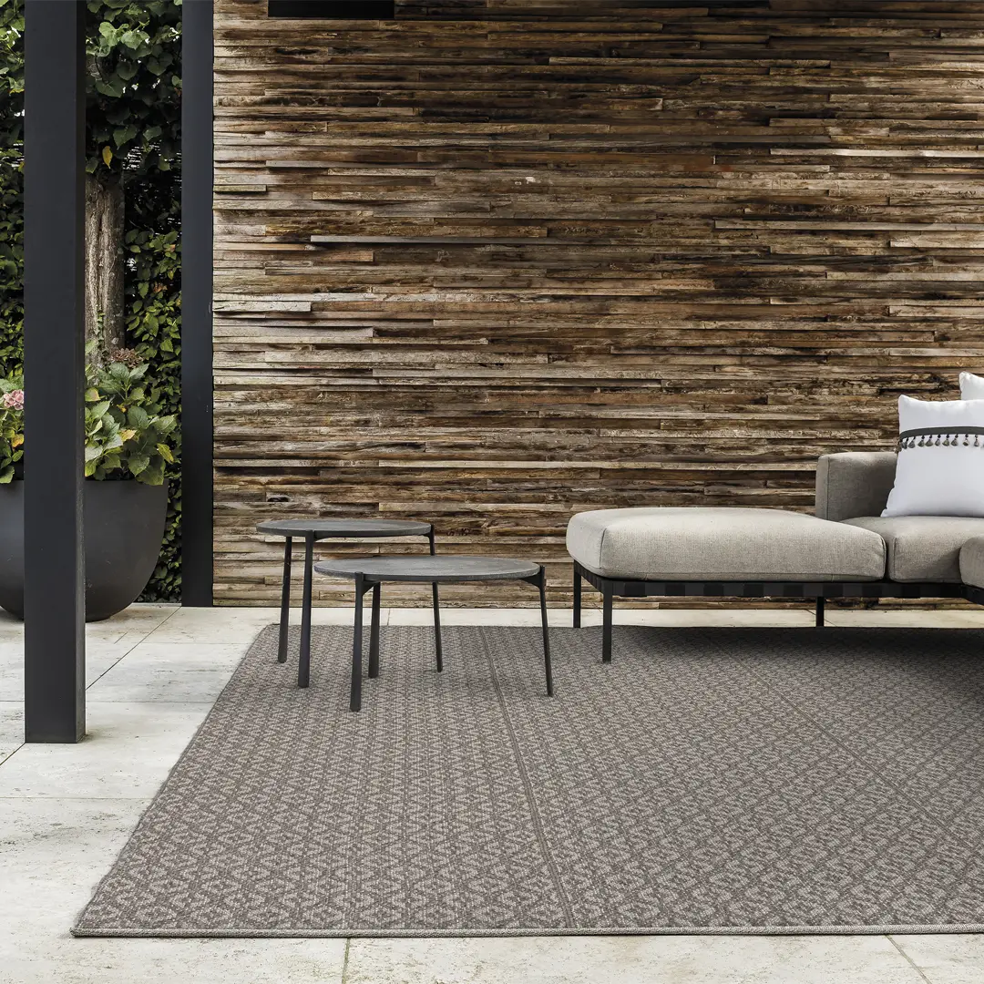 Modern outdoor furniture against a rustic wooden wall