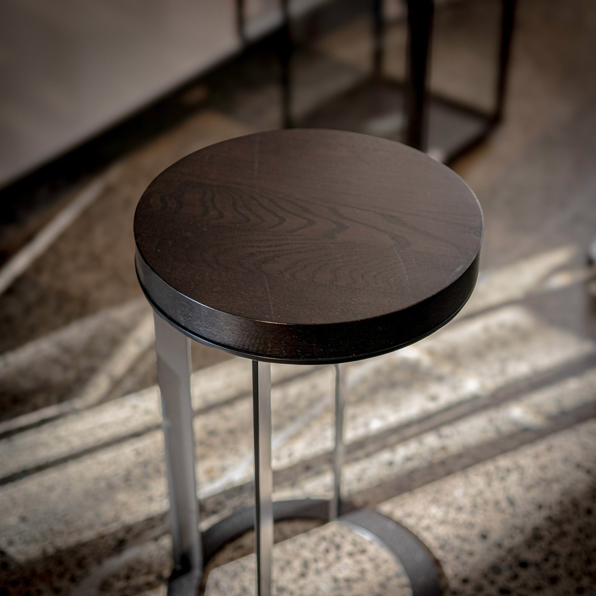 Dark wooden stool on textured concrete floor