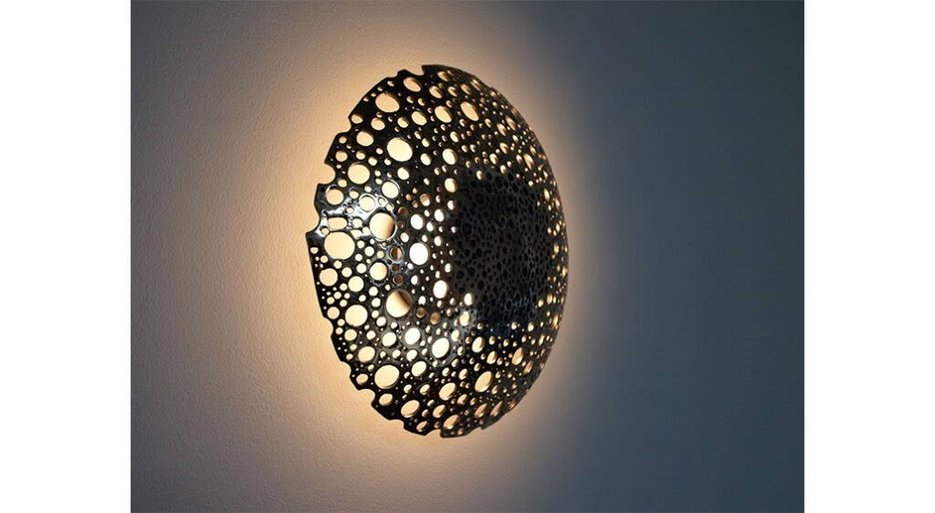 Illuminated circular wall sconce with perforated design