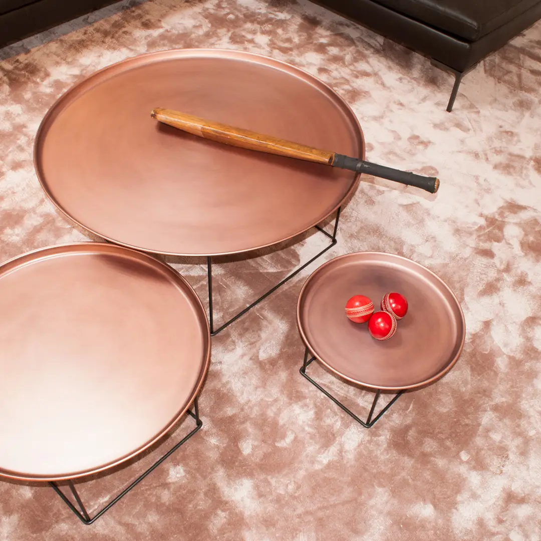 Copper trays with tomatoes and wand on marble