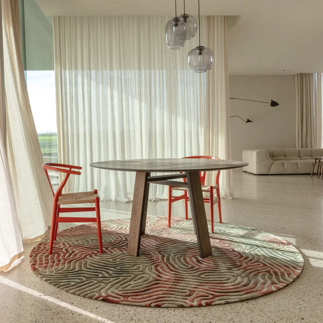 Stylish interior with round table, patterned rug, and curtains
