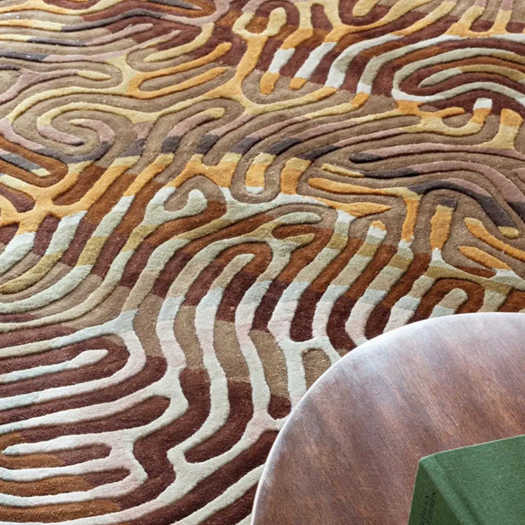 Colorful abstract patterned carpet with wooden table edge