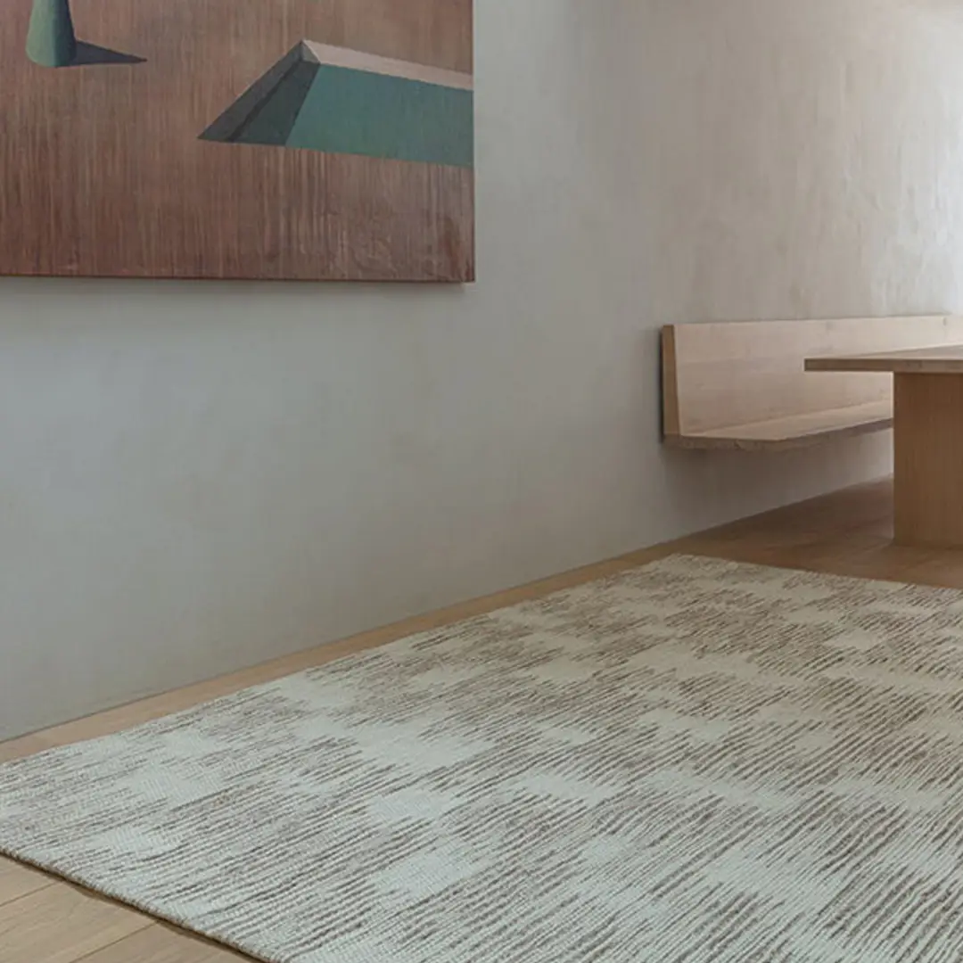 Minimalist room with wooden bench and textured rug