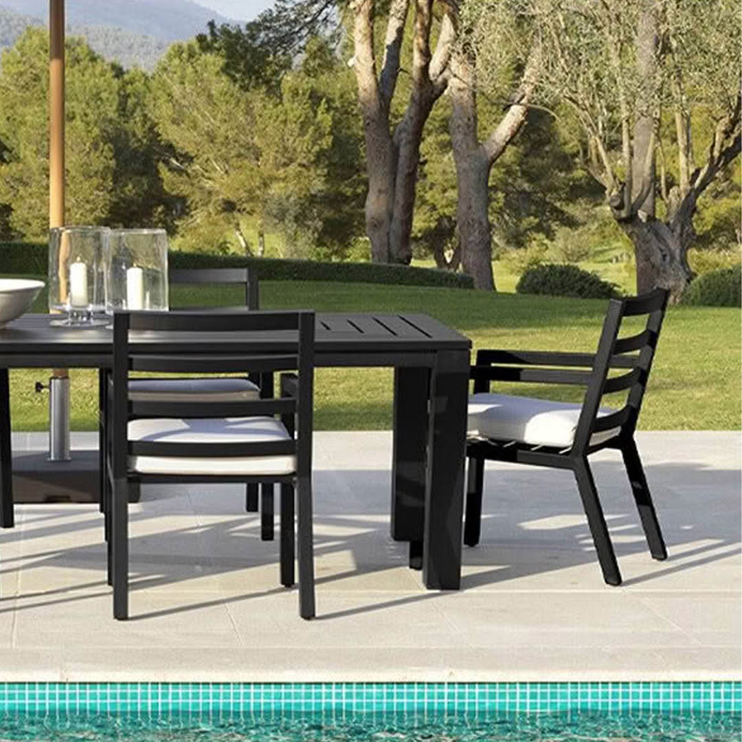 Outdoor dining set by pool with scenic background