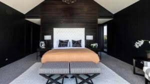Elegant black bedroom with wooden ceiling and stylish decor