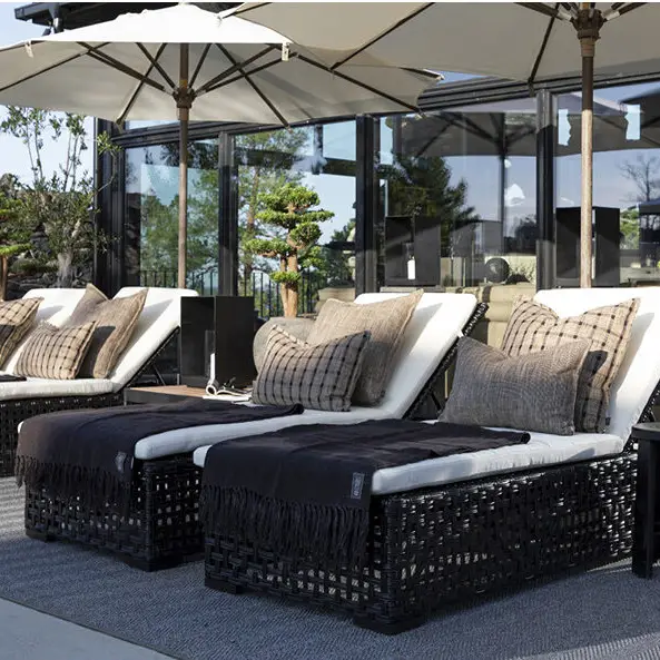 Outdoor patio with sunbeds, umbrellas, and decorative pillows