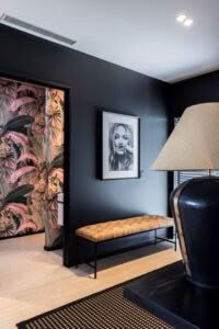 Modern room with black walls and tropical wallpaper detail