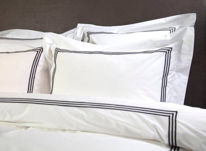 White pillows with black trim on bed