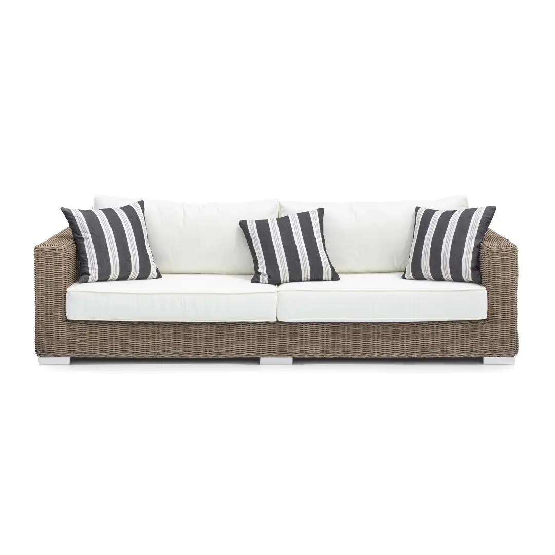 Wicker sofa with white cushions and striped pillows