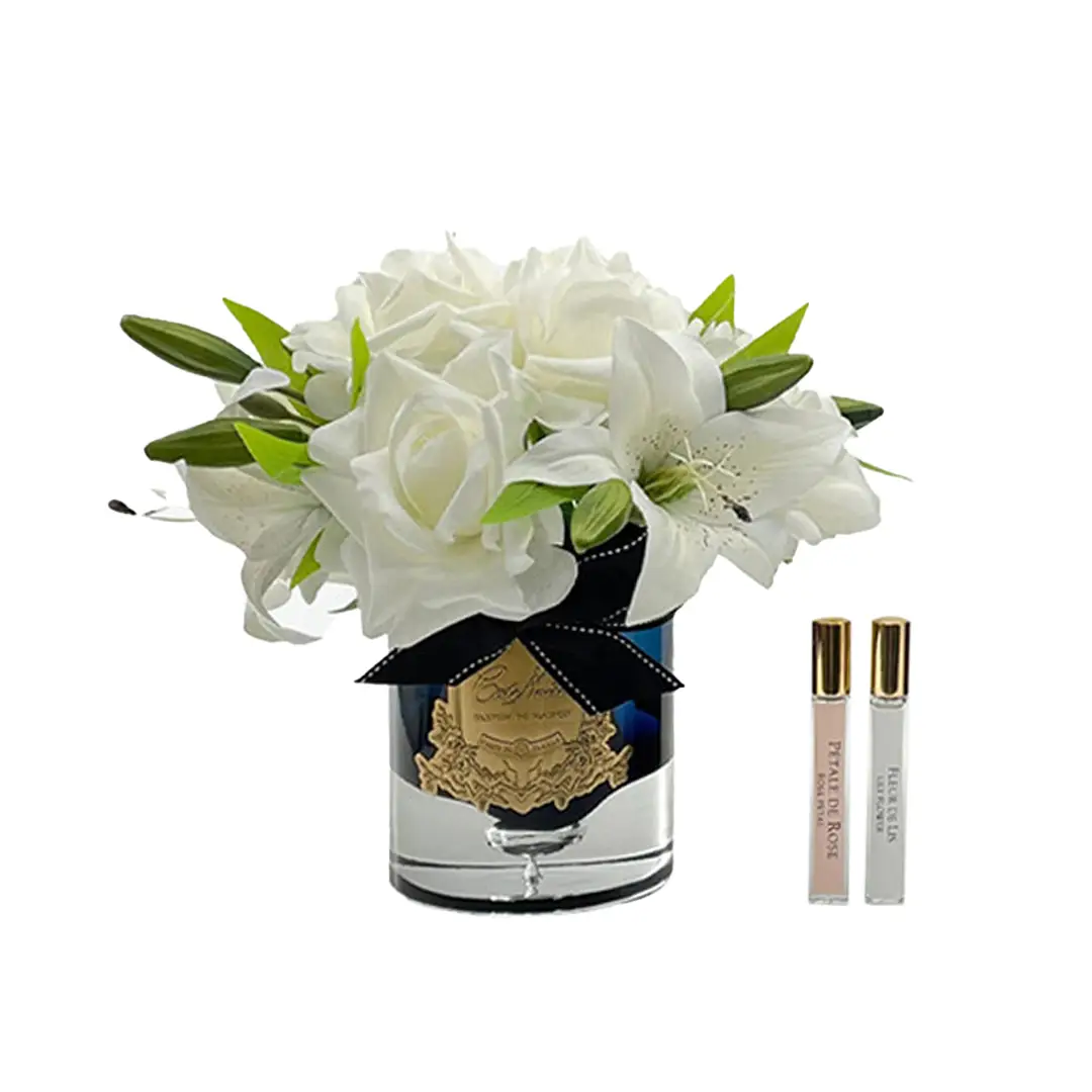 White flowers in vase with two fragrance vials