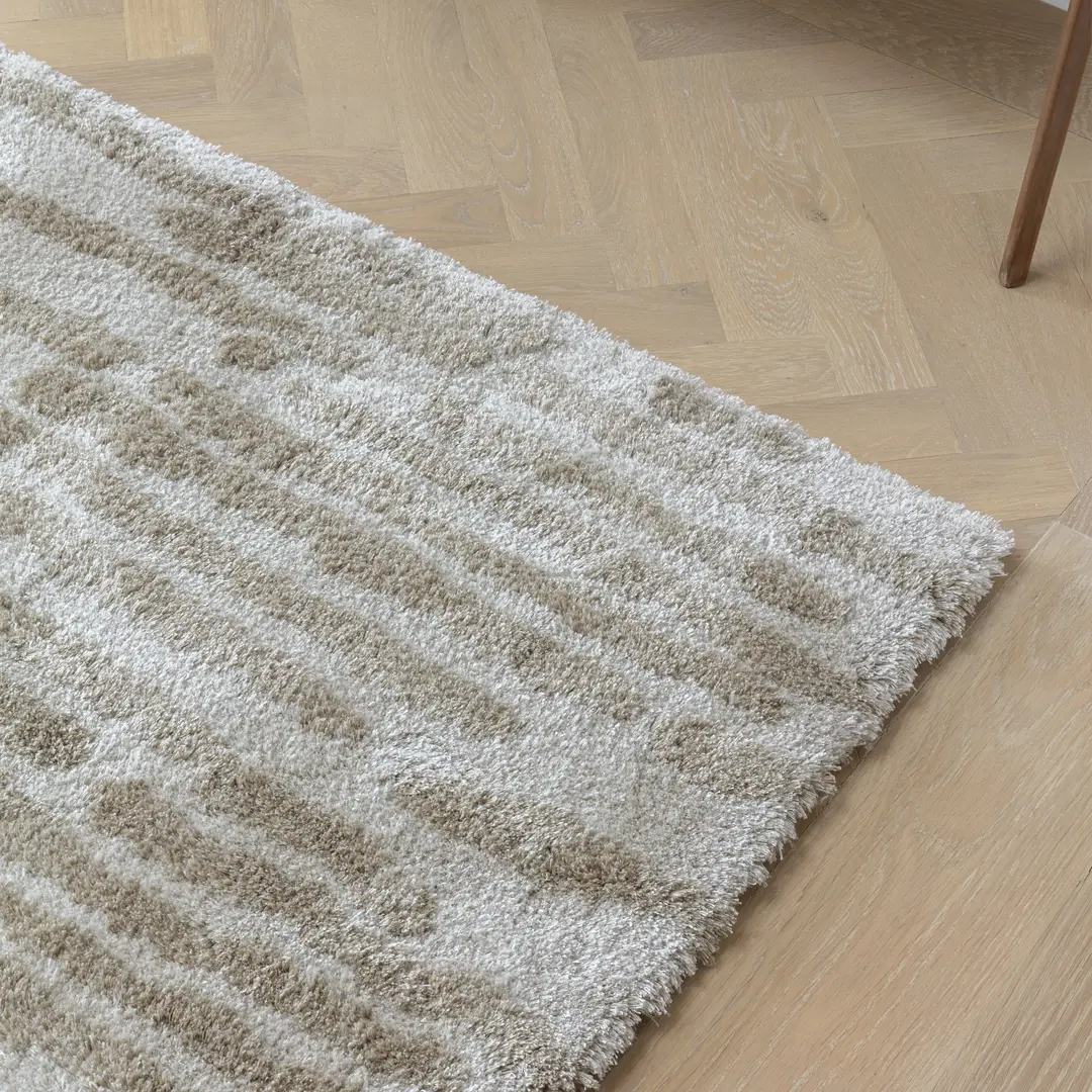 Thick textured beige rug on wooden floor