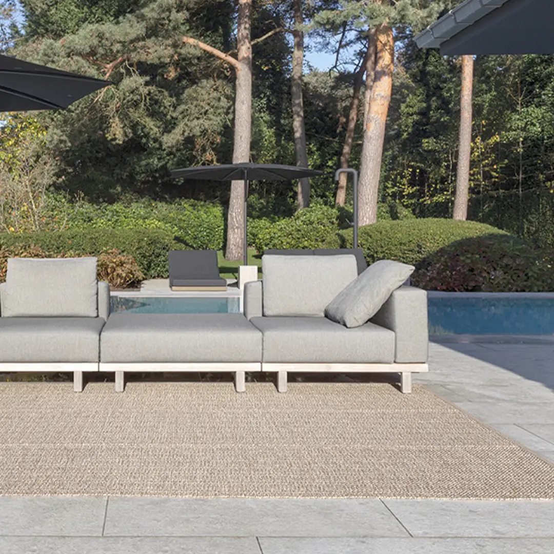 Modern outdoor patio furniture by poolside in garden