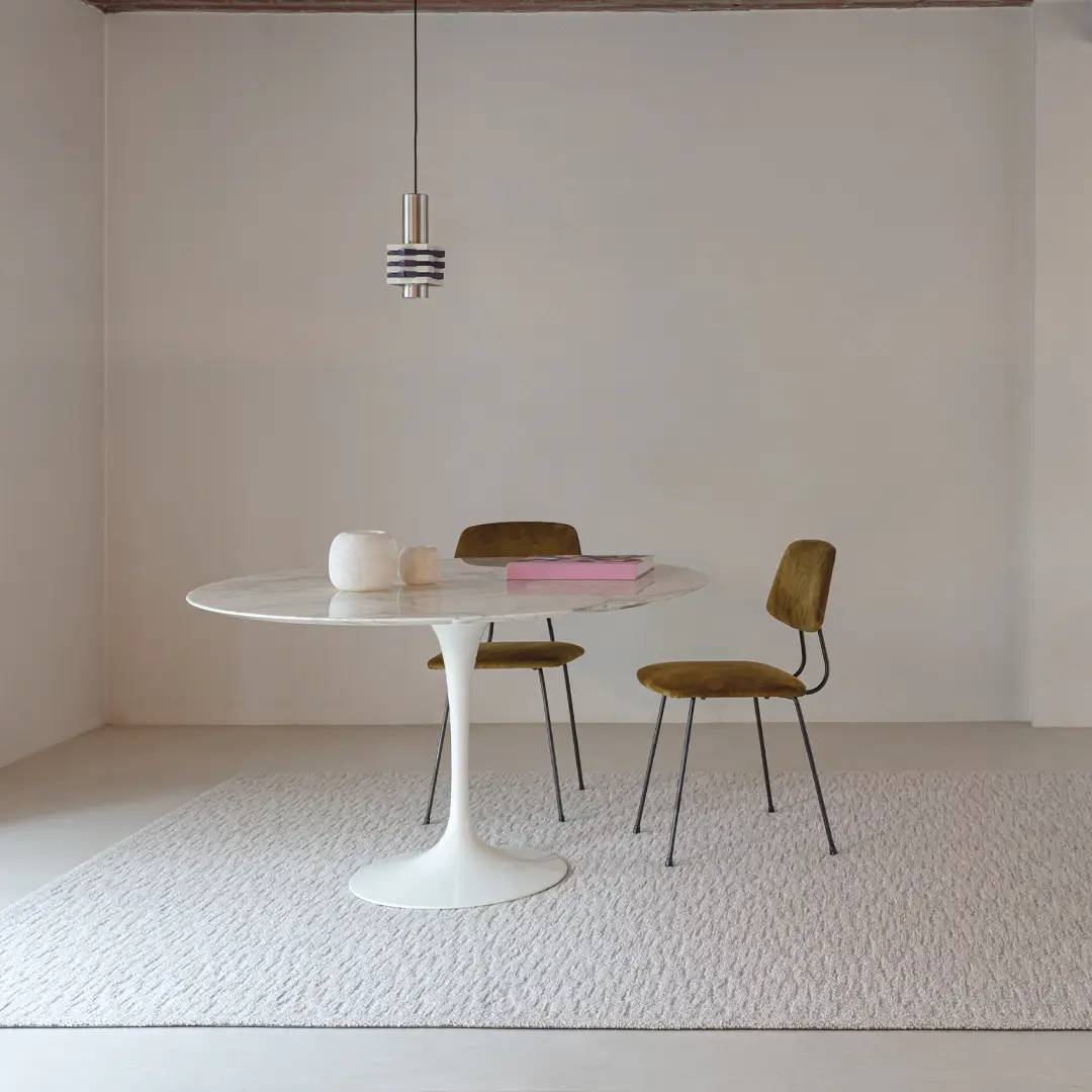 Minimalist dining area with white table and retro chairs