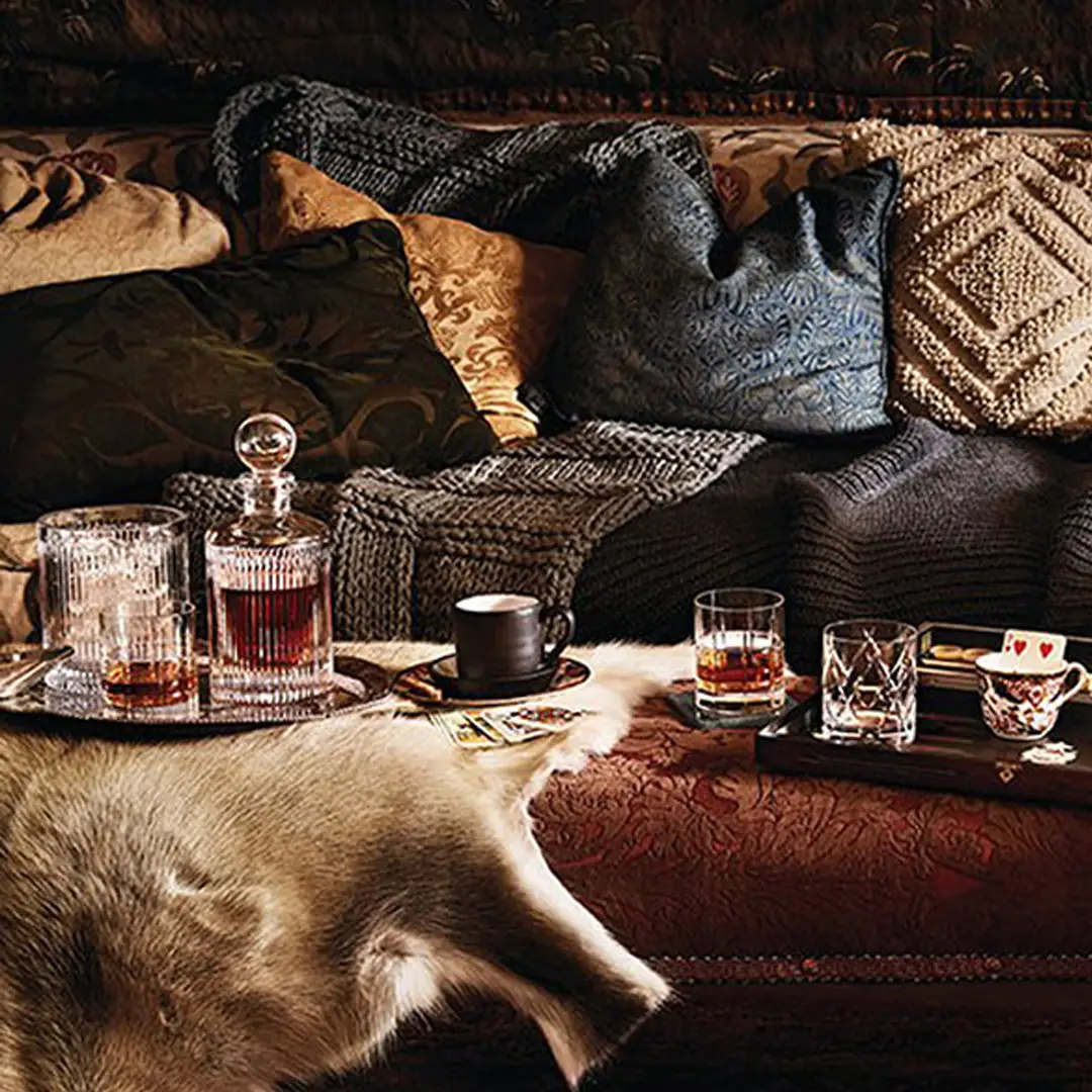 Cozy interior with blankets, drinks, and fur rug.
