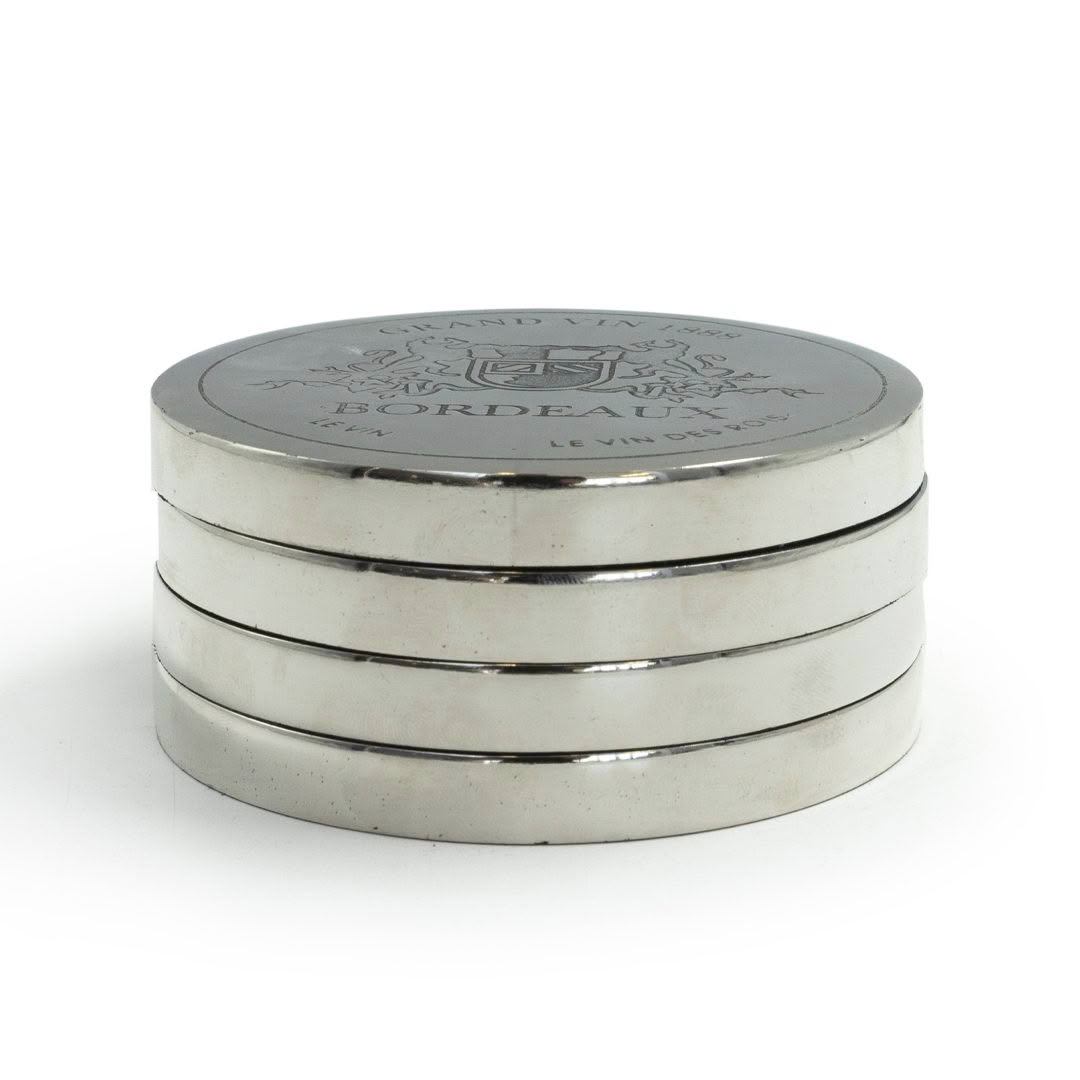 Stacked silver Bordeaux wine coasters