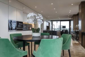 Modern kitchen with dining area and green chairs