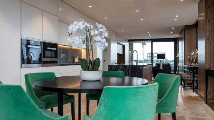 Modern kitchen with green chairs and white orchid decoration