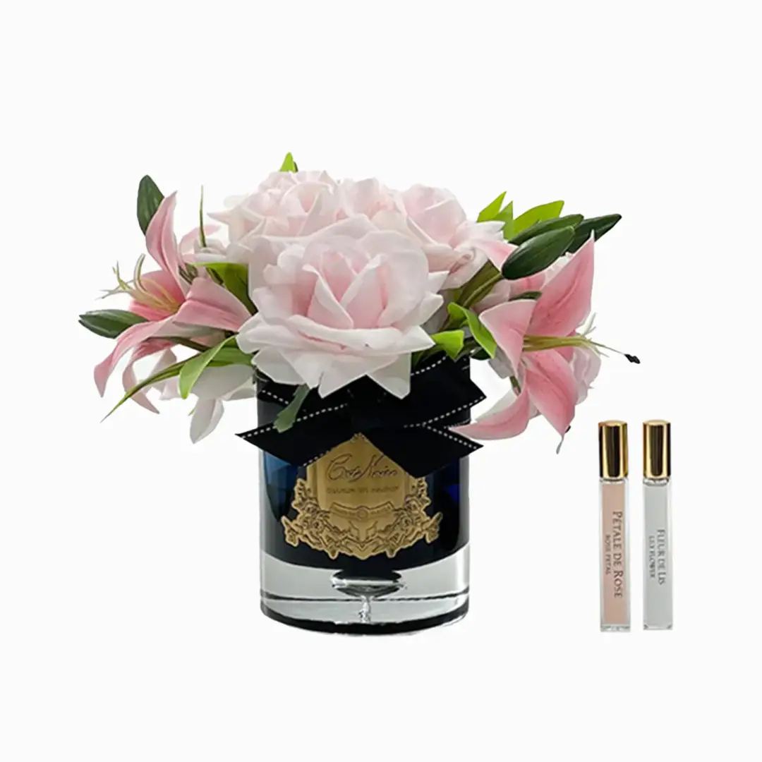 Elegant pink roses in blue vase with perfume rollers